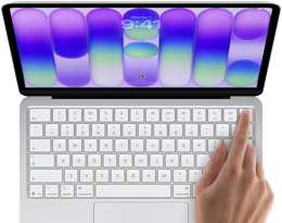 MacBook Neo, silver colour, showing login screen, person's finger on Touch ID sensor in top-right corner of keyboard